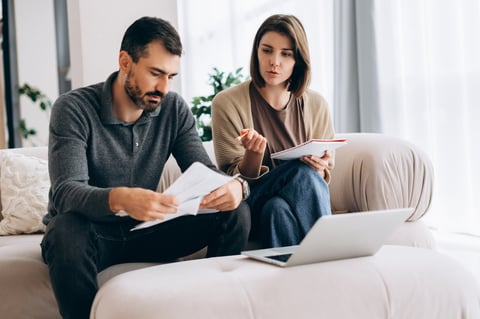 Couple planning domestic budget and checking bills in living room